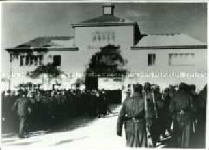 Häftlingskolonne marschiert durch das Torhaus ins KZ Sachsenhausen