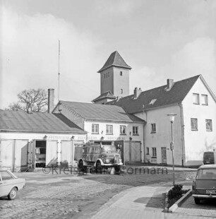 Feuerwache Woldenhorn: Schäferweg: [ehemaliges Elektrizitätswerk]: Feuerwehrgerätehaus mit Funkantenne: rechts Verwaltungsgebäude: dahinter Schlauchturm: vor Garagen Löschfahrzeug: vorne rechts Straßenlampe, parkendes Auto