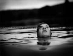 Junges Mädchen im Wasser schaut nach oben (Altersgruppe C)