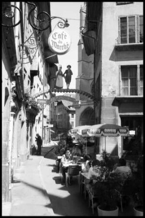 Fribourg: Gasse mit Bogen und Trachtenbild, Hintergrund Turm der Kathedrale