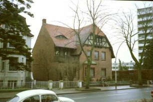 Kurparkallee 5: giebelständige Stadtvilla, Straßenfront: Backsteinbau, Giebel mit Vorkragung und Fachwerk: Querflügel mit Balkonlaube: rechts Hochhaus Liebe [angeschnitten]