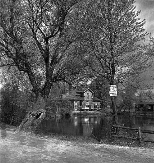 Mühlenteich: vorn Zaun: rechts und links Bäume: rechts Hinweisschild: hinten Mitte zwischen Bäumen Mühle: davor Lkw mit Anhänger: hinten rechts Schuppen