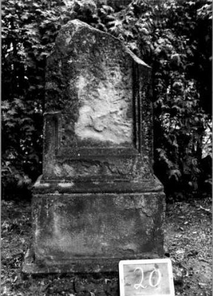 Grabstein 20 (Index: 100110427) Material: Sandstein Zustand: oben abgebrochen, stark verwittert, Schriftplatte fehlt Maße HxBxT: 133x63x25 cm Beschreibung: Stele, getreppter Sockel, eingetieftes Schriftfeld rechteckig: Grabstein 20