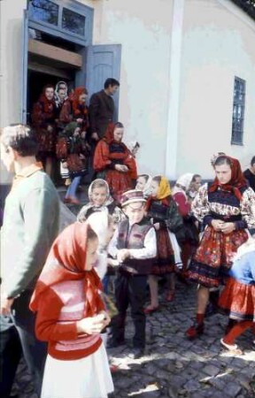 Huta Certeze: Trachtengruppen, Frauen und Kinder vor der Kirche