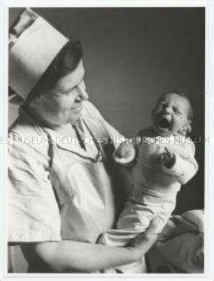 Eine jüdische Hebamme mit dem ersten jüdischen Baby nach dem Krieg