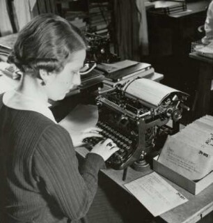 Mitarbeiterin an der Schreibmaschine überträgt Beschriftung der Negativtasche auf die Bildkarte, Sächsische Landesbildstelle, um 1937