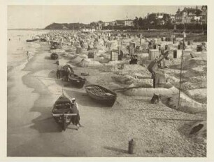 Seeheilbad Bansin. Strandleben. Zahlreiche Strandkörbe und Fischerkähne am Sandstrand. Fischer bei der Arbeit