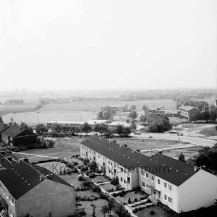 Gartenstadt Falkenberg: Wohngebäude der Greifswalder Kehre, dahinter die Straße Am Exerzierplatz, dahinter links der Sportplatz, mittig das Sportlerheim und rechts daneben die Schulgebäude der Volksschule (Gemeinschaftsschule) Harksheide: Blick vom Rathausgebäude Richtung Süden