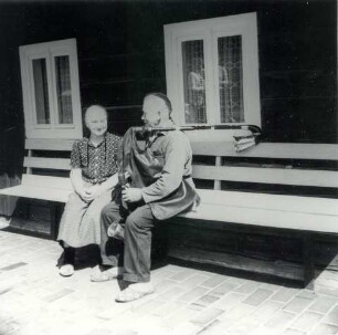 Ehepaar mit Dudelsack : Volksmusik - Interpreten und Instrumente. Ort: Trjebin/ Trebendorf. Dudelsackspieler Hanzo Schuster mit Ehefrau vor seinem Wohnhaus aus Holz, 1980