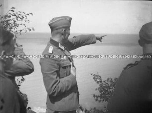 Oberstleutnant zeigt auf etwas im Hintergrund an der französischen Kanalküste
