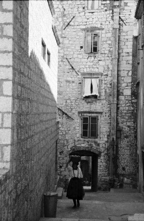 Sibenik: Gasse mit Frau, die Korb auf Kopf trägt