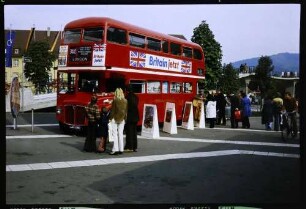 Freiburg: London-Bus auf Tournee am Karlsplatz, mit Singgruppe