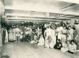 Gruppenbildnis mit kostümierten Touristen während eines Bordfestes unter Deck des Hochseepassagierdampfers "Cleveland"