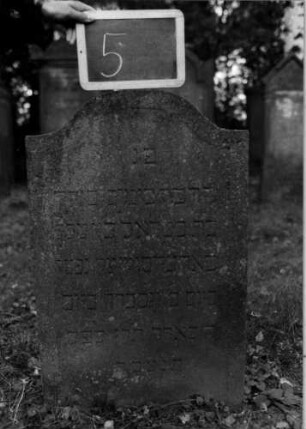 Grabstein 5 (Index: 100111013) Material: Sandstein Zustand: leicht verwittert Maße HxBxT: 85x55x10 cm Beschreibung: Stele, Konvexbogenabschluß, Schriftfeld eingetieft Besonderheit: Kindergrab: Grabstein 5