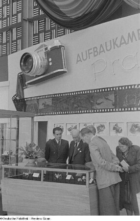 Besucher am Messestand mit Fotoapparaten (Praktica)