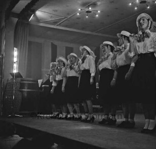 Karneval: Hotel Oldesloer Hof, Saal: Prunksitzung: Veranstalter Oldesloer Männerchor von 1844, Oldesloer Singakademie von 1946: Bühne: Auftritt von Sängerinnen der Singakademie als "Mädchenchor des NDR": links "Bütt", 27. Februar 1960