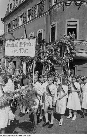 Auszug der Kinder in Festkleidung mit Propagandalosung und Blumenkränzen beim Kamenzer Forstfest