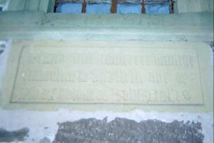 Steinplatte mit lateinischer Inschrift neben dem Eingang der Kirche