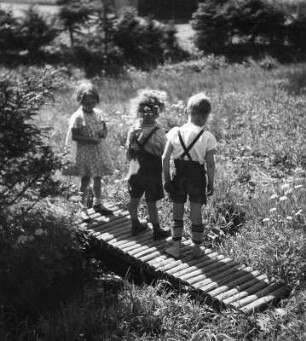 Kinderbilder. Drei Kinder auf einem Steg