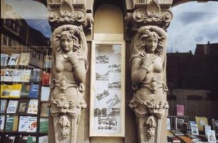 DDR. Fassadenddetail eines Erdgeschosses mit Buchladen. Ansicht mit zwei historistischen weibliche Hermen