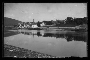 Blick vom Mainufer auf Kreuzwertheim mit Parkanlagen am Ufer, dahinter Schloss