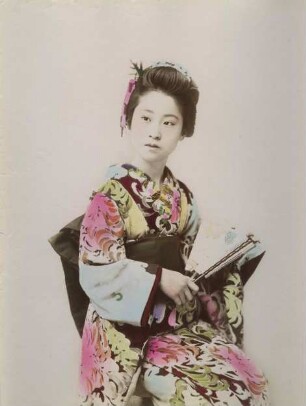 Junge Frau im Kimono mit Faltfächer und Handtasche