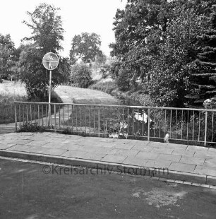 Glinder Au: links Wanderweg: vorn Brücke mit Verkehrsschild: hinten Bäume