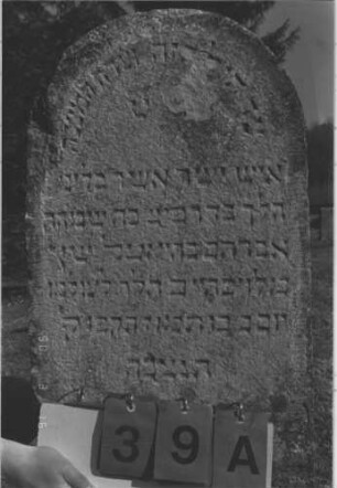 Grabstein 39 (Index: 100009531) Maße HxBxT: 102x44x6 cm Besonderheit: kulturhistorisch wertvoll / hist.-wiss. Gründe (Gemeindestellung): Grabstein 39A