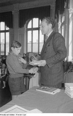 Überreichen von Büchern an einen Jungen (Pionier)