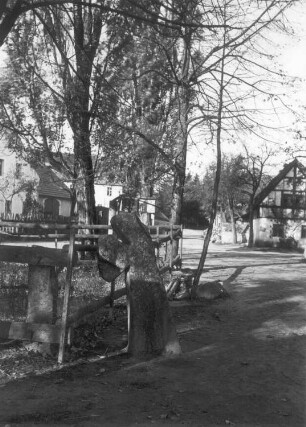 Steinkreuz : Puschwitz, Steinkreuz (Tatzenkreuz) mit Abschlägen an Armen mit eingeritztem Schwert am Dorfteich