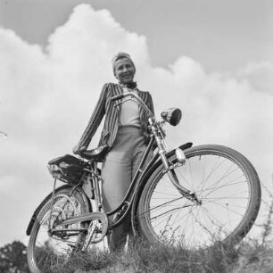 Elisabeth Gremmler mit Sonnenbrille steht hinter ihrem Fahrrad