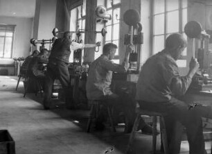 Radebeul-Kötzschenbroda. Elektroarmaturenwerk JWH. Werkhalle der Fräserei (?). Arbeiter an Maschinen