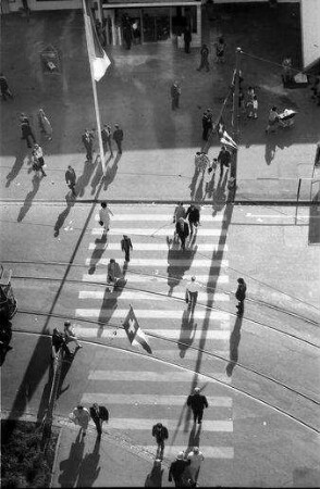 Basel: Fußgänger auf Zebrastreifen, von oben mit langen Schatten, vom Neubau der MUBA [Mustermesse Basel]