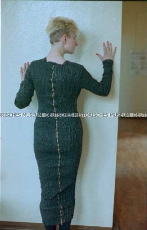 Modell in schwarzem Lederkleid mit Reißverschluss (Rückseite) der Designergruppe Allerleirauh