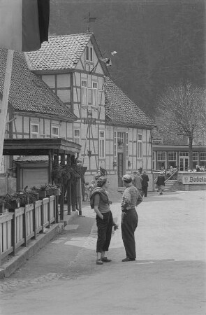Straßenszene mit Urlaubern im Bodetal, links das Hotel Bodetal