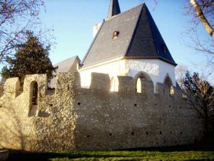 Ansicht von Ostsüdosten-innere Kirchhofmauer mit Zinnen und Schießscharten (restauriert) über Feldseite (hier Teil der Ortsbefestigung-einst vorgelagerte zweite Mauer abgetragen)
