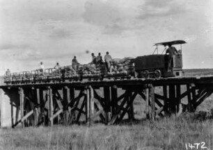 Zug auf Holzbrücke : Triebwagen und Transportwagons auf einer Holzbrücke.