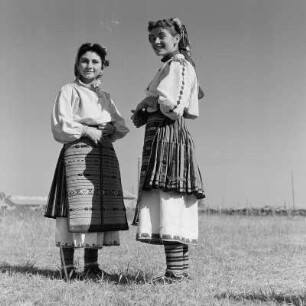 Tanzgruppe. Tänzerinnen einer Folkloregruppe in bulgarischer Tracht. Porträt zweier Tänzerinnen der Tanzgruppe