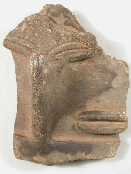 Part of the face of a clay figure (with nose jewellery)