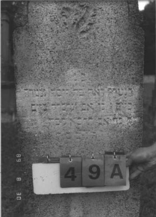 Grabstein 49 (Index: 99609685) Material: Kunststein Zustand: verwittert, gerissen Beschreibung: Stele, Bögchenabschluß, getreppter Sockel Symbolik: floral: Grabstein 49A
