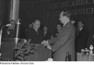 Portrait von sich beglückwünschenden Männern an einem Rednerpult