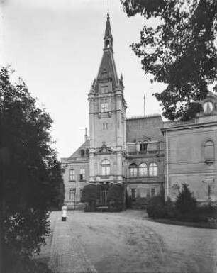 Schloss. Teilansicht mit Turm und Wappenstein