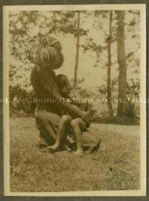 Seitenansicht einer Waschamba-Frau mit Kleinkind auf ihrem Schoß