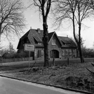 Tralau: Schulstraße: Volksschule: altes Schulgebäude am Ortseingang: davor Bäume: links Ortseingangsschild: