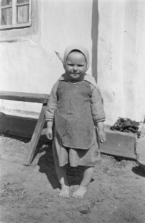 Zweiter Weltkrieg. Zur Einquartierung. Sowjetunion. Kleines Mädchen vor einer Bauernhütte