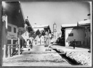 Ein Wintertag in Mittenwald : Mittenwald. Obermarkt mit Wohn- und Geschäftshäusern. Blick zur Pfarrkirche St. Peter und Paul. Winteraufnahme