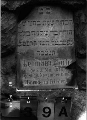 Grabstein 39 (Index: 100105482) Material: Muschelkalk, weiße Marmorplatte Zustand: Platte mehrfach gesprungen und Teile herausgebrochen Maße HxBxT: 106x43x26 cm Beschreibung: Stele, rustica, konische Schriftplatte mit Segmentbogenabschluß: Grabstein 39A