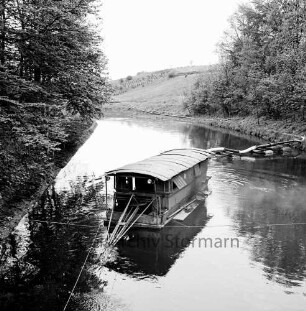 Trave: Entschlammungsarbeiten: Blick von Friedensbrücke auf Schwimmbagger mit Saugrohren: rechts und links am Ufer Bäume: im Hintergrund Wiesen
