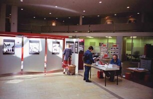 Sparkasse Holstein: Hauptstelle in der Hagenstraße: Halle im Erdgeschoss: Besucher am Bücherstand zur Kindervogelschießenausstellung des Kreisarchivs, Archivmitarbeiter Manfred Holzgreve am Tisch sitzend