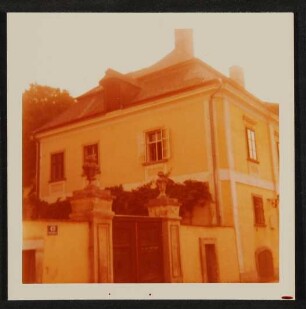 Farbfotografie von Hofmannshtals Haus in Rodaun mit Eingangstor von der Straße aus
